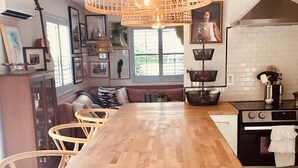 A modern kitchen with a wooden island, pendant lighting, and a stove. - Charming Olde Naples Bungalow  (Naples)