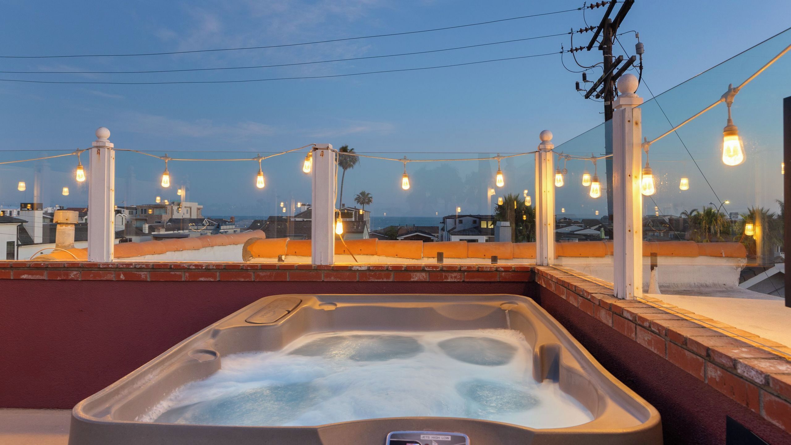 Un jacuzzi con vistas a la ciudad y luces cálidas.