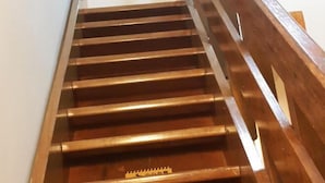 Egy fából készült lépcső, fém korláttal.