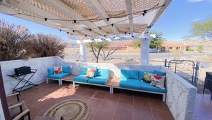 A covered outdoor seating area with a sofa set, a small table, and a rug. - Charming 2-bedroom house with WiFi, AC in welcoming Yucca Valley (Yucca Valley)