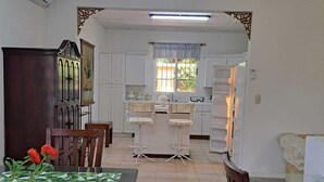 Un comedor con una mesa dispuesta para dos, un aparador de madera y una alfombra estampada.