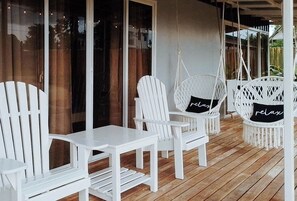 A wooden deck with white furniture, including chairs and a table. - Angels Bed And Breakfast Sipalay City By Reddoorz (Sipalay)
