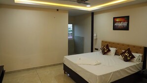 A hotel room with a bed, a ceiling fan, recessed lighting, and a painting on the wall.