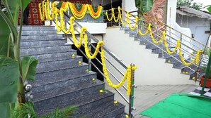 A staircase with yellow garlands, leading to a building with a mural.