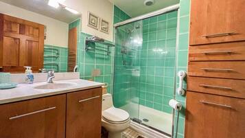 A bathroom with a shower, toilet, and sink.