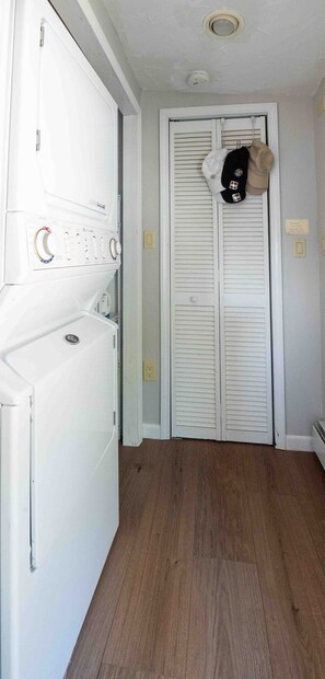 A laundry room with a dryer, a white door with a closet, and a ceiling vent. - Sunset Paradise Cottage (Aurora)