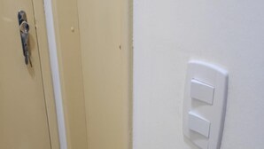 A beige door with a silver handle and a white wall with a white switch. - Ideal Apartamento em Curitiba (Curitiba)