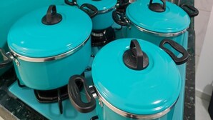 A kitchen with four teal-colored pots on a stove. - Ideal Apartamento em Curitiba (Curitiba)