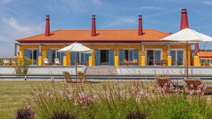 A yellow building with red chimneys, outdoor seating, and a clear sky. - Resort Rural Quinta do Carrascal (Rio Maior)