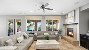 A spacious living room with a large sectional sofa, a coffee table, and a fireplace. - Desert Oasis in Palm Springs/Indio, California (Indio)