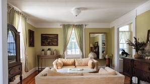 A living room with a beige sofa, a round coffee table, and a wooden cabinet.
