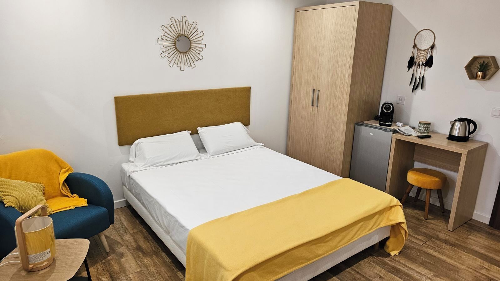 Un dormitorio ordenado con cama, escritorio, armario y silla.