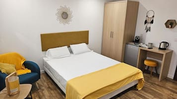 Un dormitorio ordenado con cama, escritorio, armario y silla.