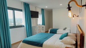 A bedroom with two beds, a TV, and a view of the city. - Bed and Breakfast Equitare Rural  (Miranda do Corvo)
