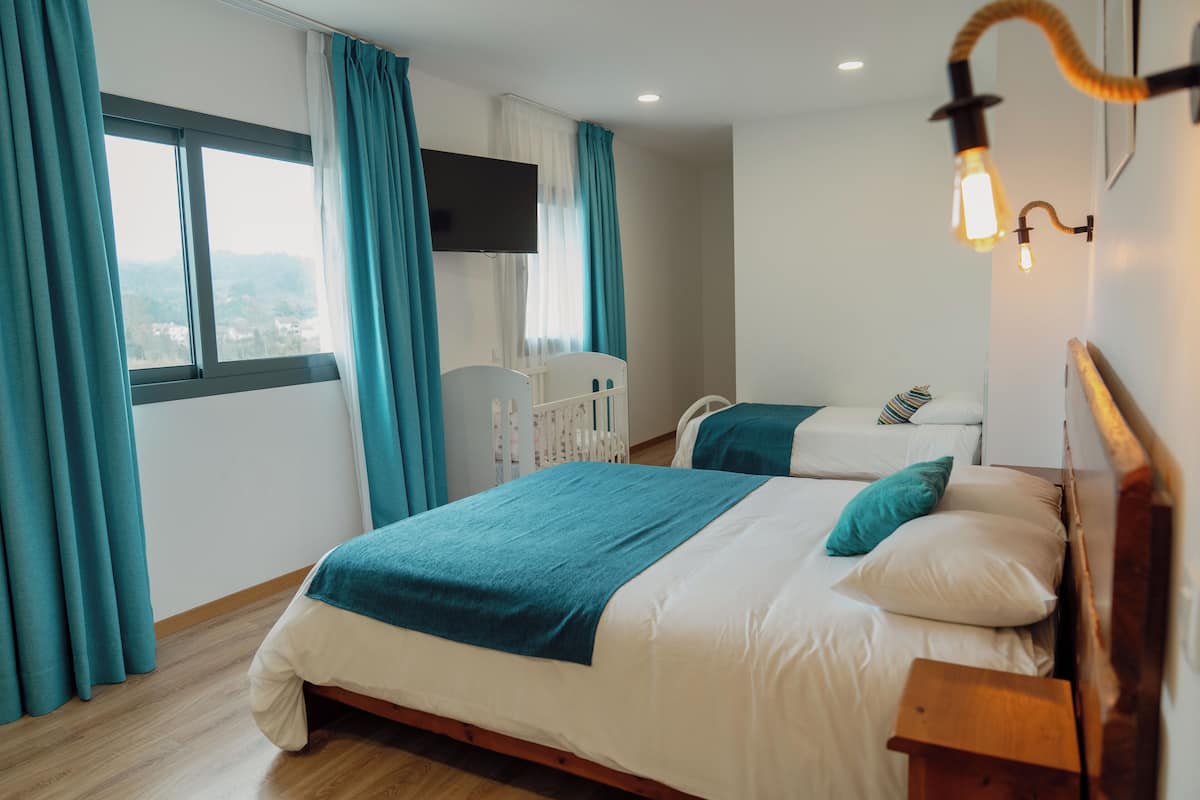 Une chambre avec deux lits, une télévision et une vue sur la ville.
