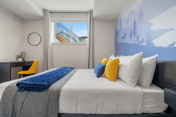 Bedroom with a queen bed, dedicated workstation, closet & blackout blinds.