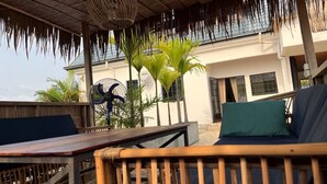 Une terrasse en bois avec un ventilateur, une chaise et une table.