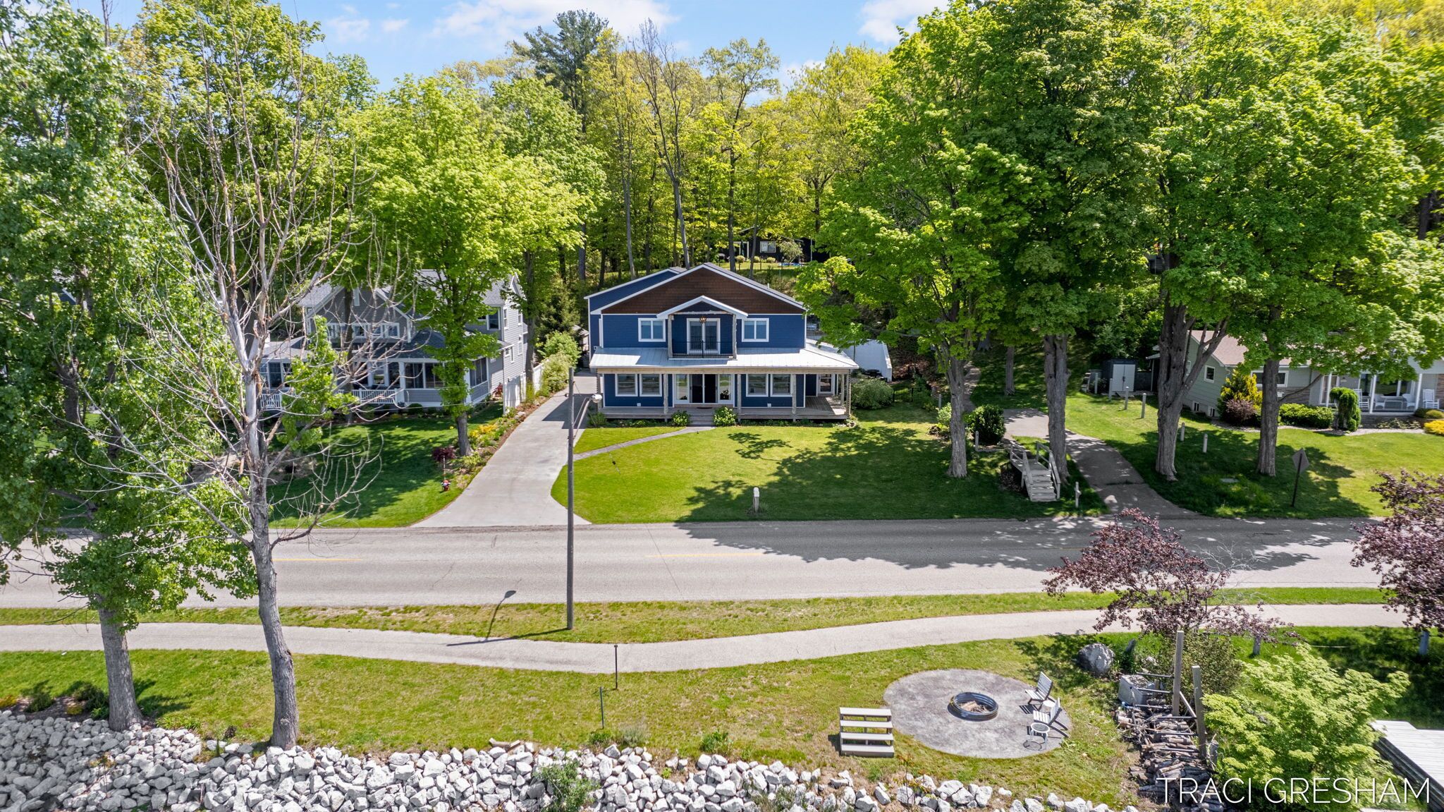 A two-story house with a front porch, surrounded by trees and a well-maintained lawn.