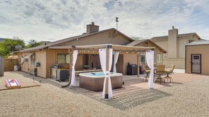 Un jardin avec un jacuzzi, un patio couvert et un espace salon extérieur.