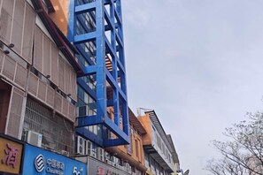 A multi-story building with a blue structural element and signage for China Mobile. - Songyi Hotel Songjiang University Town Rongfeng Life Square Branch (Shanghai)