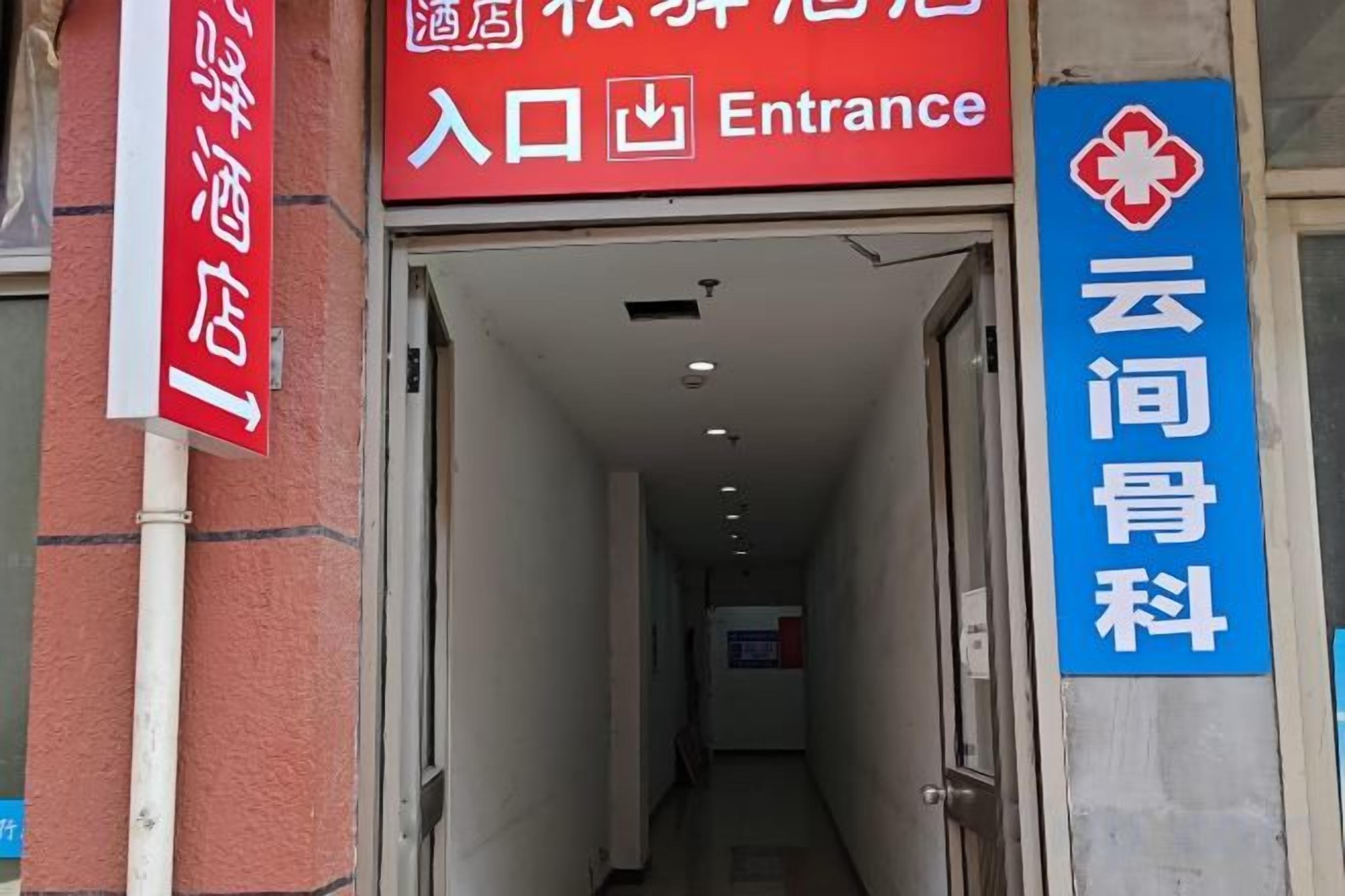 Entrada de hotel con un cartel que indica acceso y un centro médico.
