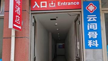 Entrada de hotel con un cartel que indica acceso y un centro médico.