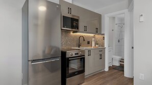 Una cocina moderna con electrodomésticos de acero inoxidable, microondas, horno y fregadero.