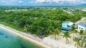 Une propriété située sur la côte, dotée d’une plage, d’une végétation luxuriante et de quelques bâtiments.