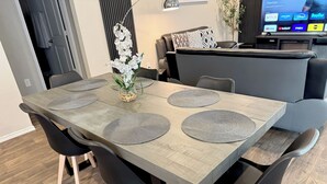 A dining area with a rectangular table, black chairs, and grey placemats. - Modern 3br/2ba with 3 king beds · Pool · Pets OK! (Patton Village)