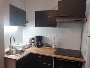 A compact kitchen with a sink, a coffee maker, and a toaster.