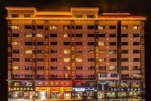 A multi-story hotel with a row of shops on the ground floor. - Lanzhou Xindeli Hotel (Lanzhou)