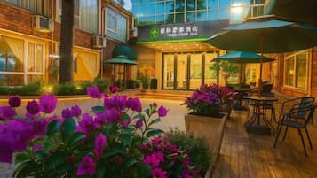 A hotel with a modern exterior, outdoor seating area, and a sign indicating it is a hotel.