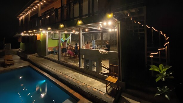 A poolside area with a covered seating area and a bar.