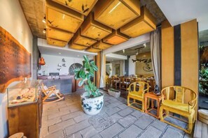 A traditional interior with wooden furniture, a reception desk, and a potted plant. - Wendao Panxiyuan Lake View Inn (Dali City)