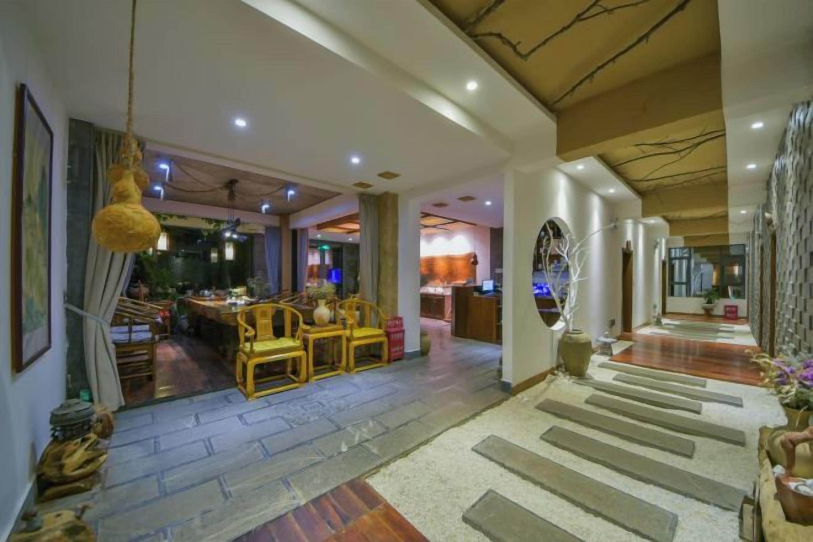 Un vestíbulo amplio con una escalera, un comedor con mobiliario de madera y una zona de bar.