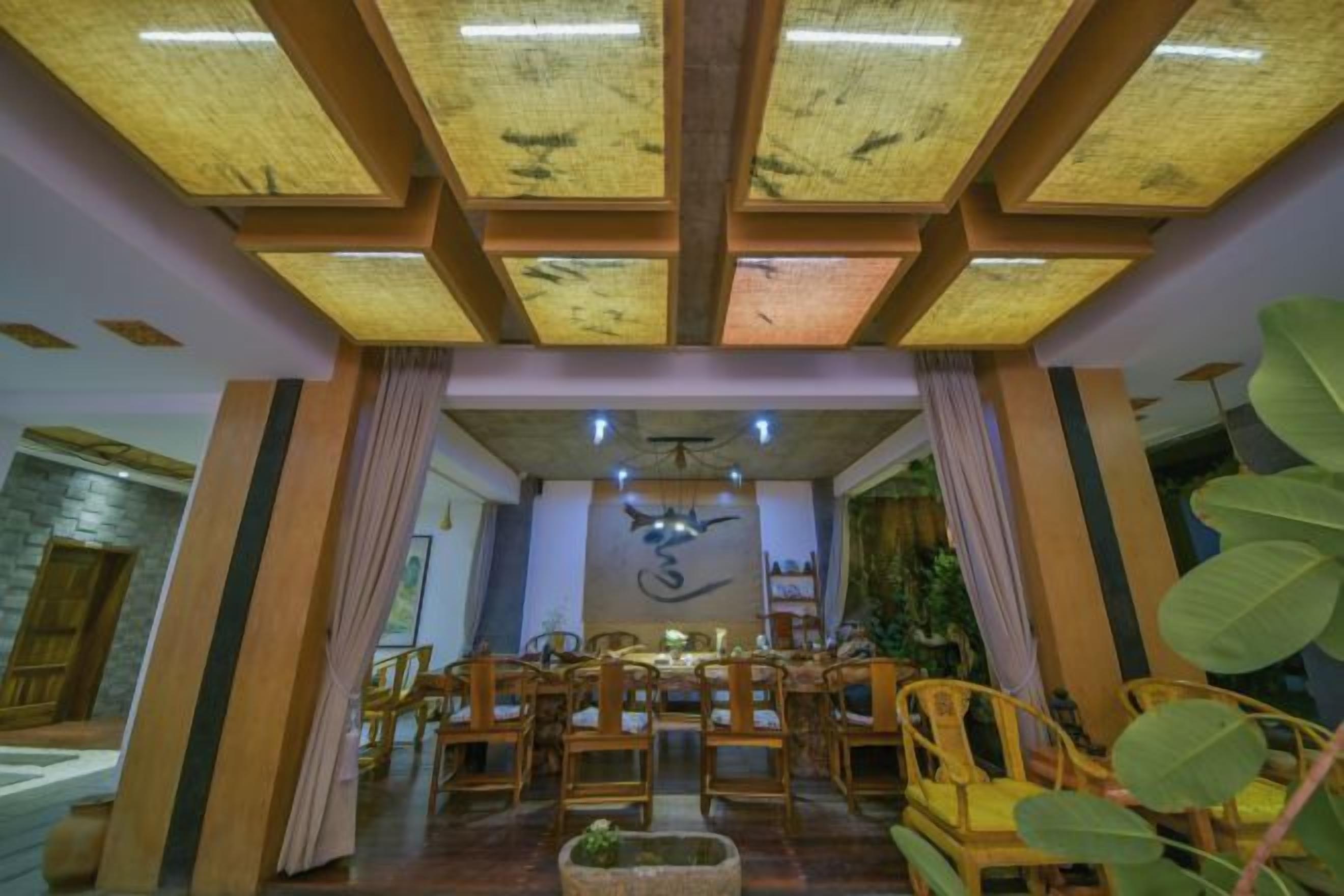 Una habitación con techo alto, vigas de madera y un candelabro central.