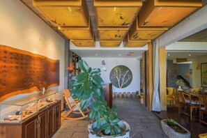A lobby with a wooden ceiling, a large plant, a seating area, and a wall with calligraphy. - Wendao Panxiyuan Lake View Inn (Dali City)