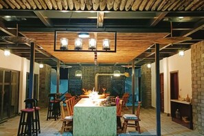 A dining area with a long table, chairs, and a central fire feature. - Wendao Panxiyuan Lake View Inn (Dali City)