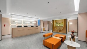 Een moderne receptiebalie met zitplaatsen en een decoratieve wand.