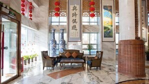 A lobby with a marble floor, a sofa set, and traditional Chinese lanterns. - Baicheng Hexiang Hotel (Civic Plaza Haiming East Road Pedestrian Street Store) (Baicheng)