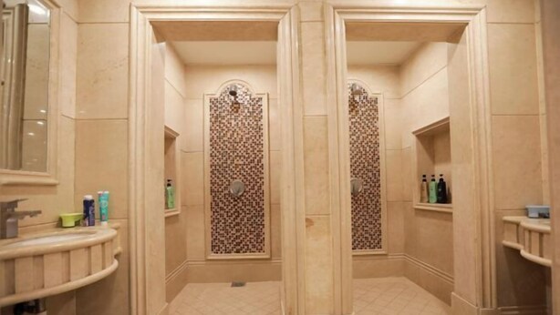 A bathroom with two shower stalls, a sink, and a mirror. - Baicheng Hexiang Hotel (Civic Plaza Haiming East Road Pedestrian Street Store) (Baicheng)