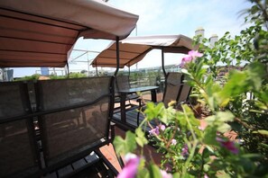Outdoor seating with umbrellas, a table, and chairs.
