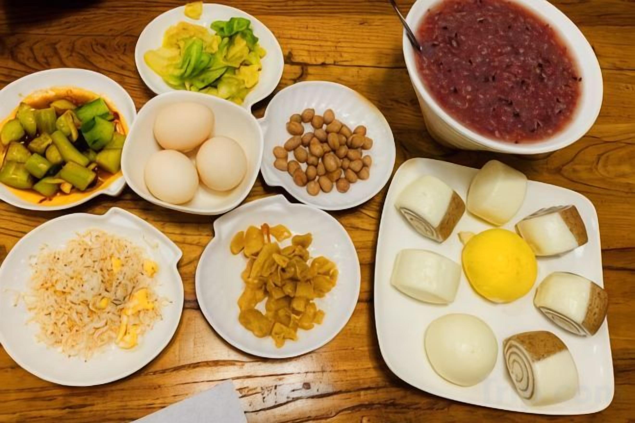 A wooden table with various food items including eggs, beans, and vegetables.