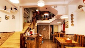 A restaurant with wooden furniture, a staircase, and a view of the street. - Kulangsu Xinyuan Inn (Longtou Road Snack Street) (Xiamen)