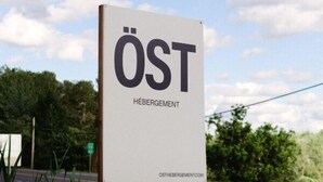 Een bord met de tekst 'ÖST HÉBERGEMENT' en een website-adres.