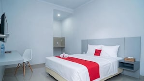 Una camera d'albergo con un letto, una scrivania, una sedia e una televisione.