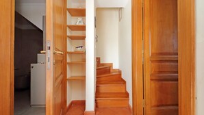 A hallway with a wooden staircase, a white door, and a tiled floor. - Spanish Steps apartment with view by Flatinrome (ROMA)