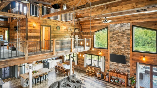 Eine geräumige, mehrstöckige Holzhütte mit Essbereich, Küche und Wohnzimmer.