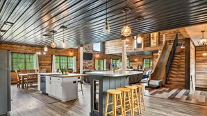 Eine geräumige Küche mit einer großen Kochinsel, Holzböden und rustikalem Interieur.