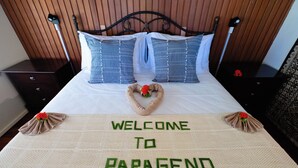 Ein Bett mit Fußmatte, Kissen und einer dekorativen Herzform.